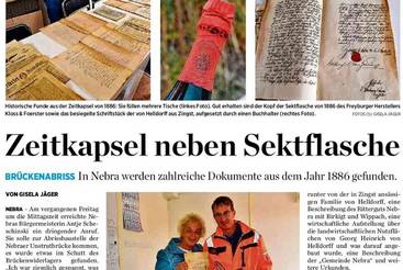 Zeitkapsel neben Sektflasche